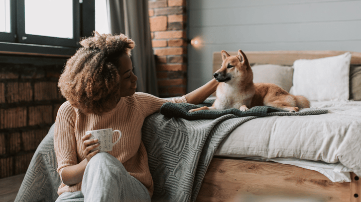 Women petting her dog at home, symbolising pawternity leave at work