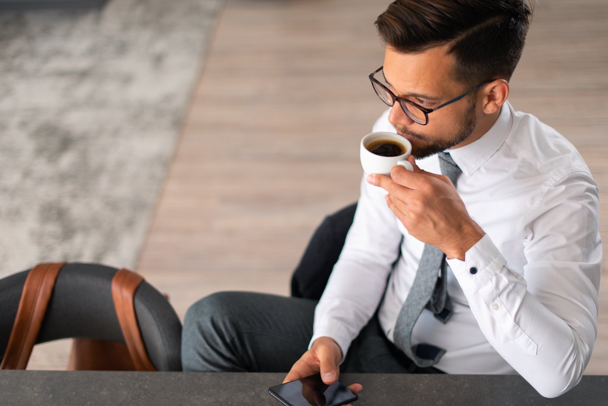 Young businessman drinking coffee in the morning at work