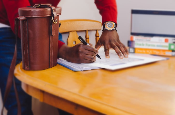Man ondertekend papieren op tafel