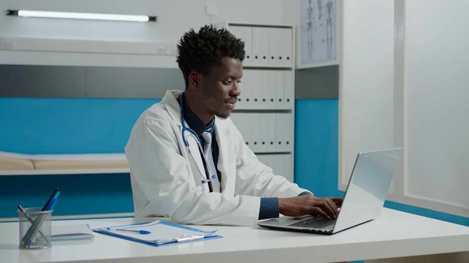 male African American doctor working on laptop in office