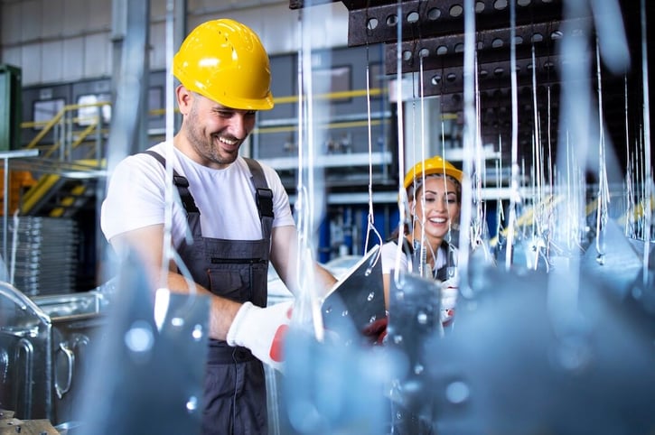 Moderne Produktionshalle eines Unternehmens, das kürzlich Insourcing-Methoden implementiert hat, mit Arbeitern an Hochtechnologie-Maschinen.