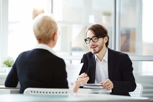 mehr Gehalt im Job : Mitarbeiter bei einer Gehaltsverhandlung mit dem Vorgesetzten auf der Arbeit