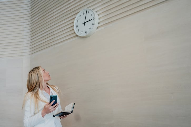 manager looking at the clock symbolising excessive tardiness at wok