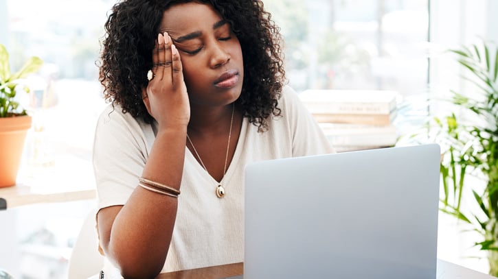 business woman looking stressed while working in office symbolising burnout