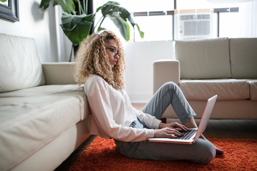 business woman working sitting comfortably on the floor working on laptop