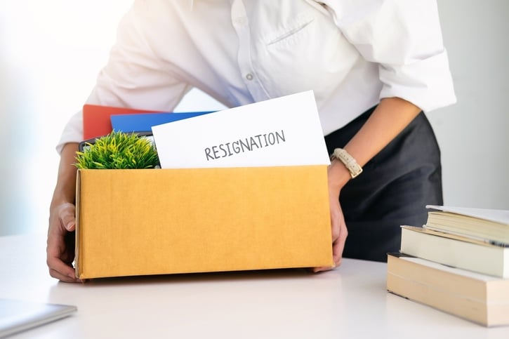 employee packing up desk with resignation letter inside