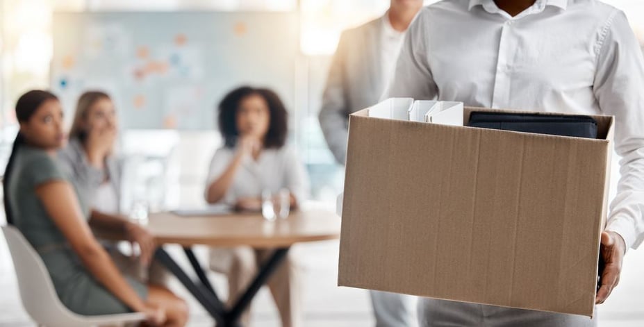 dismissed employee caring box with belongings as he leaves office