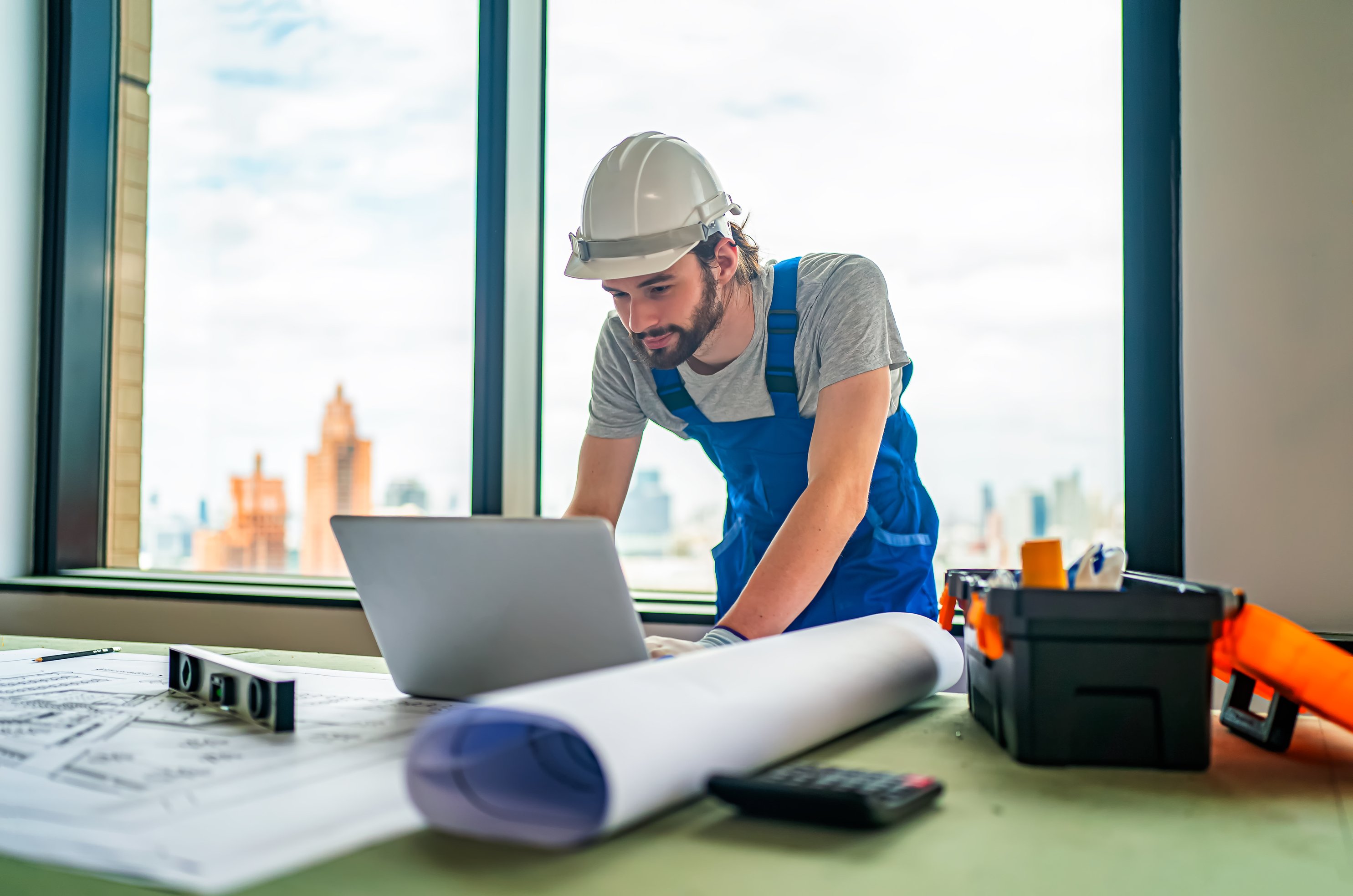 construction engineer or foreman worker checking data on laptop