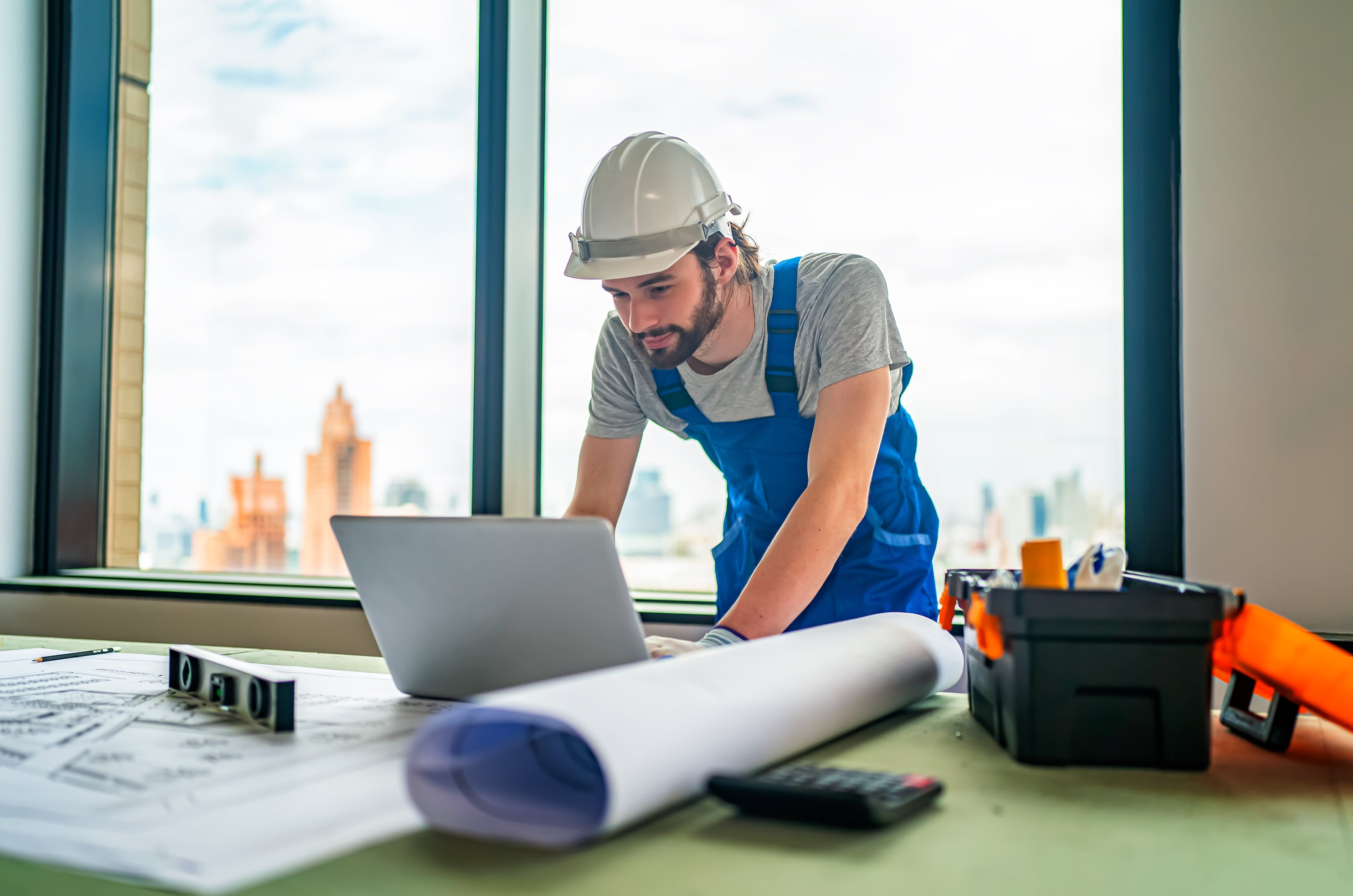 construction engineer or foreman worker checking information on laptop
