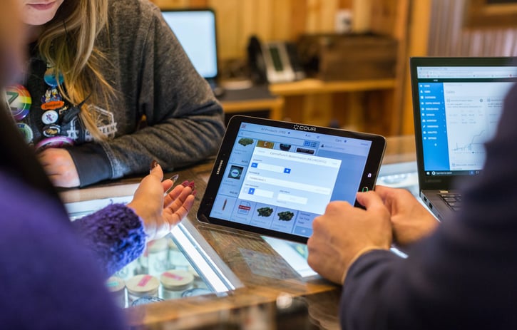Mensen kijken samen naar 1 tablet en overleggen