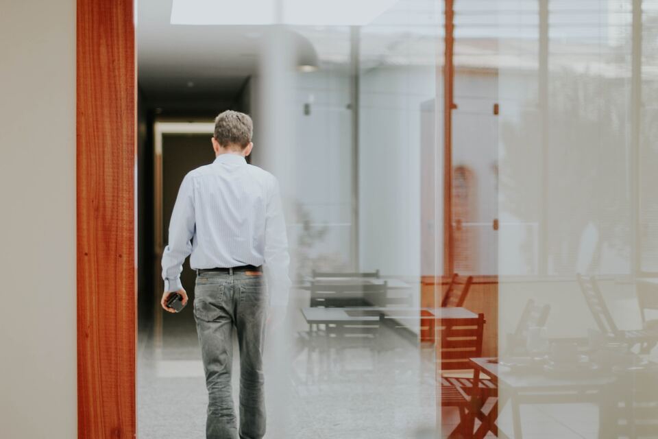 creative shot of man walking into empty office