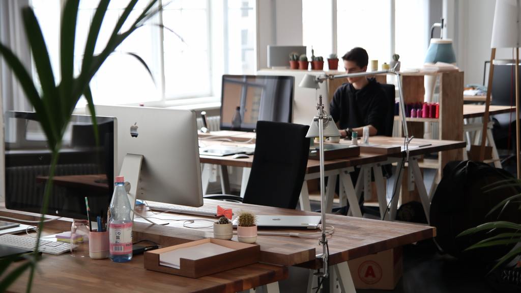 creative shot of office environment with employee working at his desk