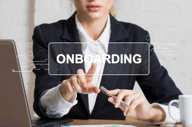 Junge Mitarbeiterin nimmt an einer digitalen Onboarding-Schulung über ihren Laptop teil.