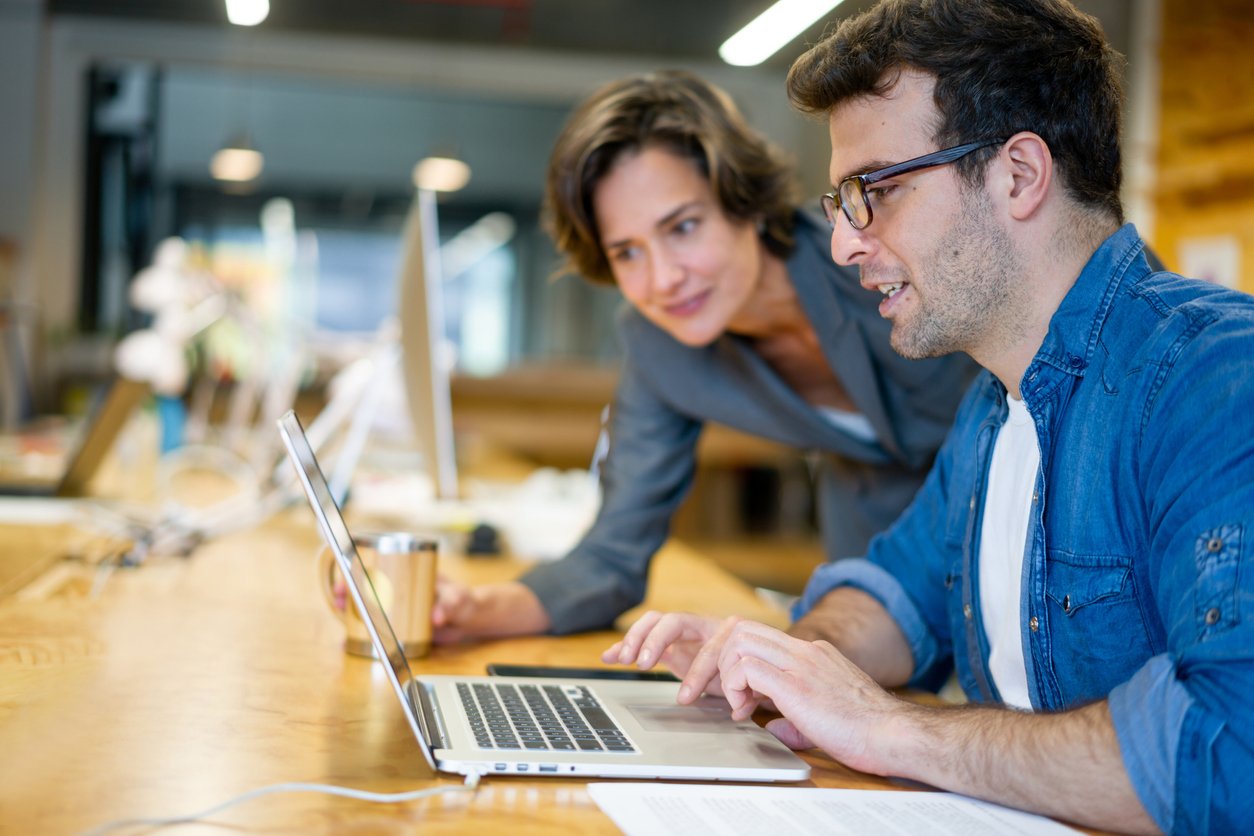 male and female working together on a project looking on laptop screen