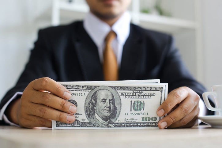 employee holding dollarsmoney in hand symbolising double time pay