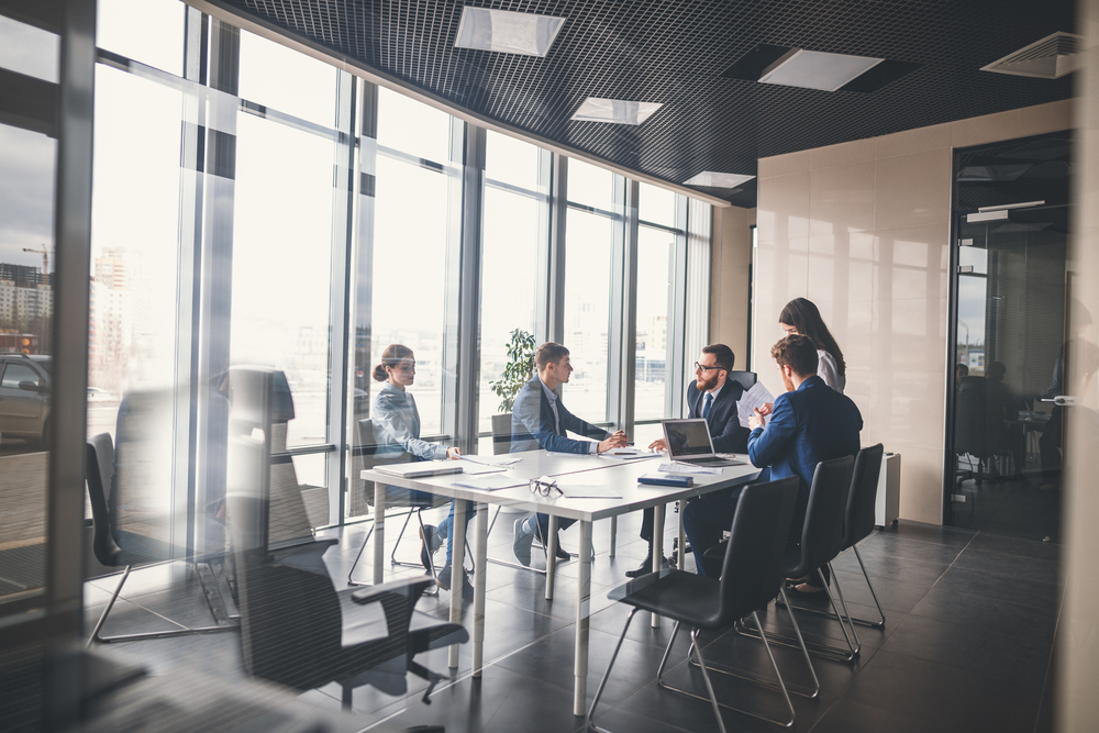 employees sitting in a meeting room discussing project