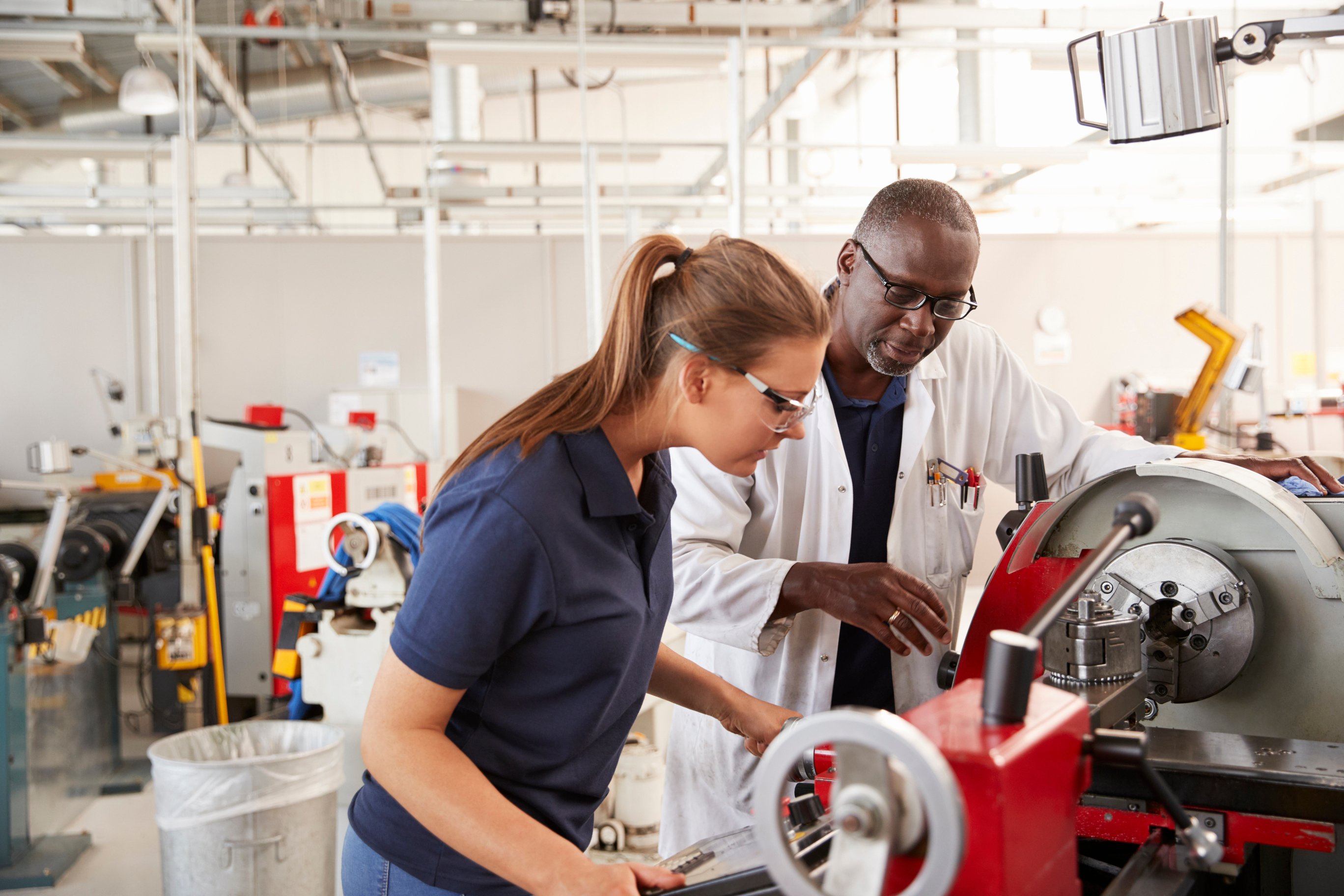 engineer showing new employee or apprentice how the machine works