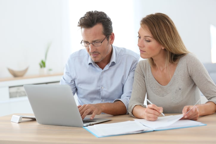 executives working together looking at data on laptop