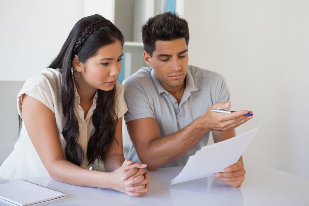 Casual business team reading document together at desk in the office