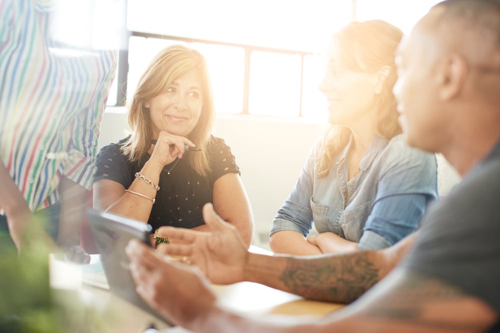 Unposed group of creative business people in an open concept office brainstorming their next project.-2