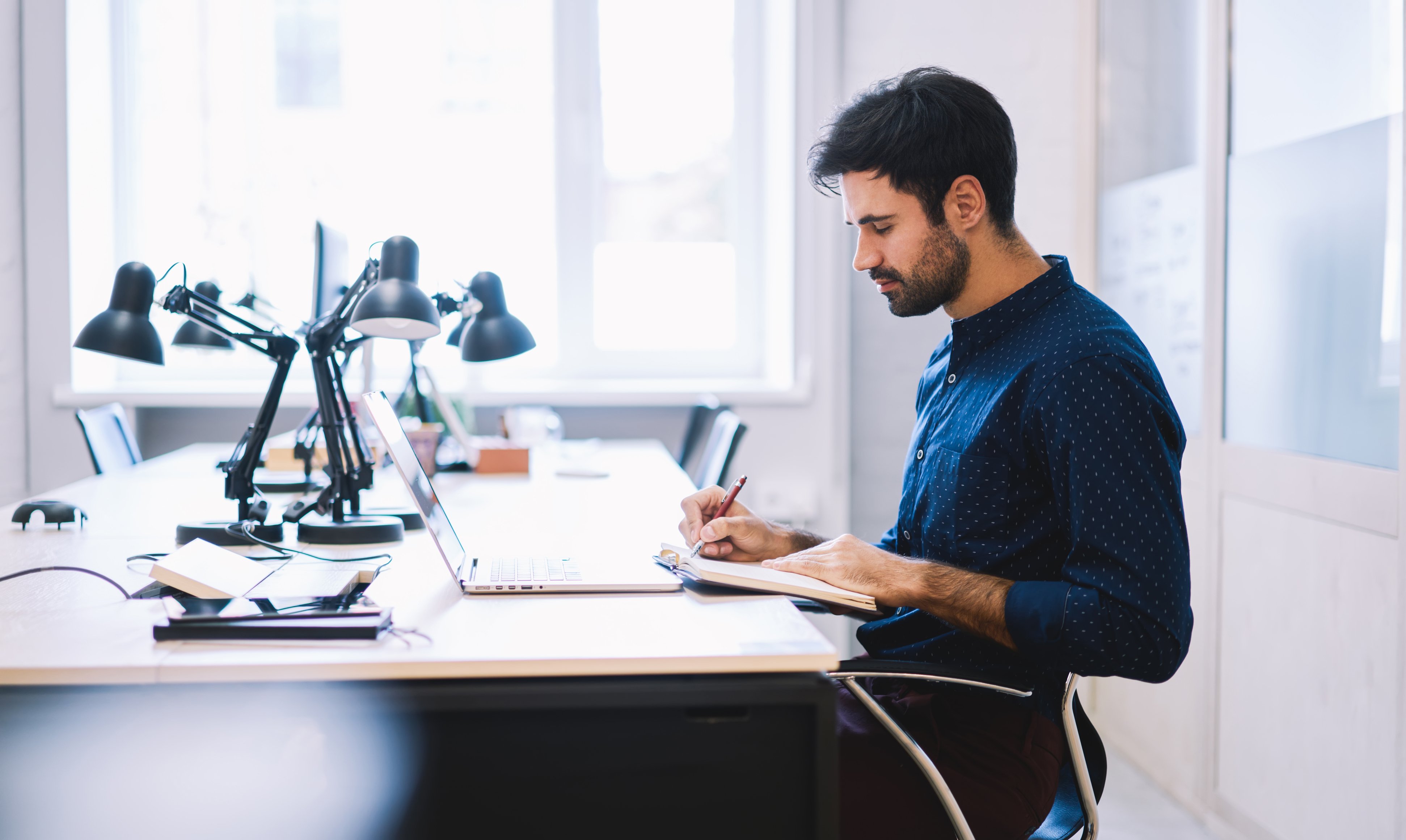 focused company employee writing in notepad in