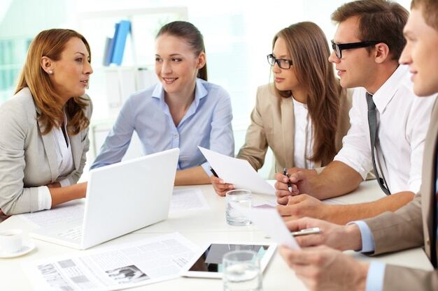 Büroangestellte nutzen verbale Kommunikation während eines Meetings.