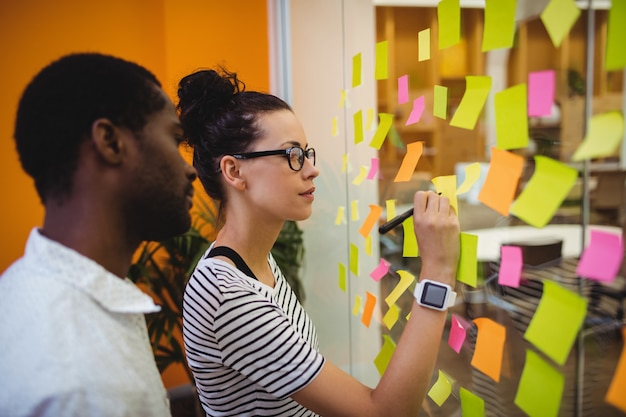 Teammitglieder diskutieren agiles Arbeiten an einem Scrum-Board
