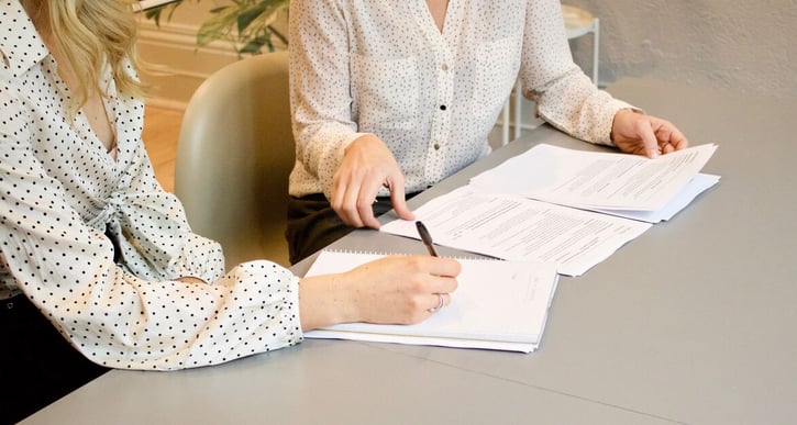 Vrouwen zitten aan tafel en bespreken contract