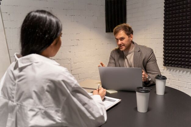 Ein Unternehmensberater und ein HR-Manager diskutieren über alternative Wiedereingliederungsmaßnahmen für einen Mitarbeiter, der nach längerer Krankheit Schwierigkeiten bei der Rückkehr in den Job hat.