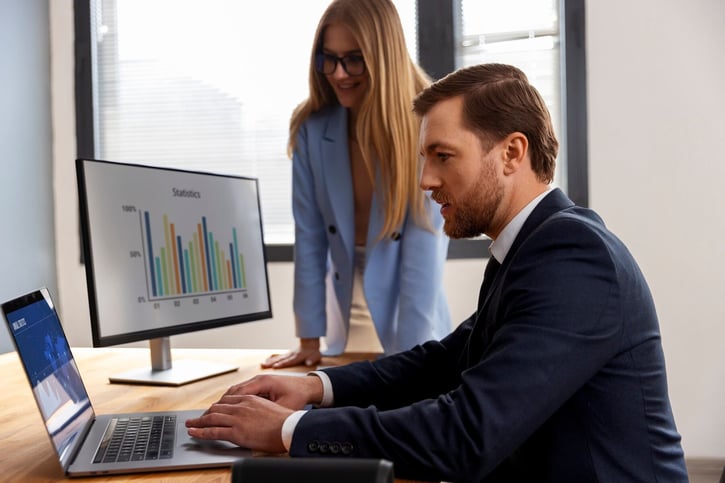 Büromitarbeiter analysieren Daten zur Fluktuation auf einem Computerbildschirm, um Arbeitsabläufe zu verbessern.