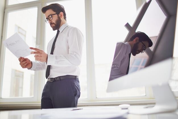 Entgeltabrechnung: Unternehmer prüft Bericht über Gehaltsabrechnung im Büro