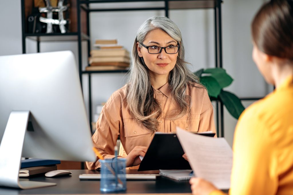 gray haired female hr manager with glasses job candidate