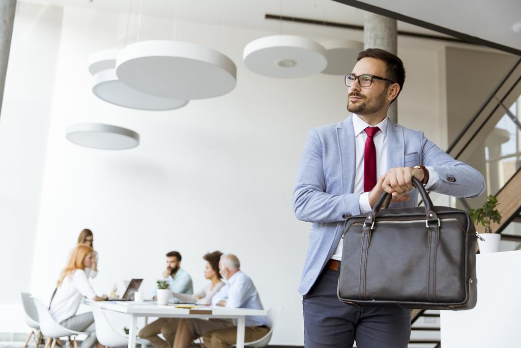 handsome businessman leaving office for vacation