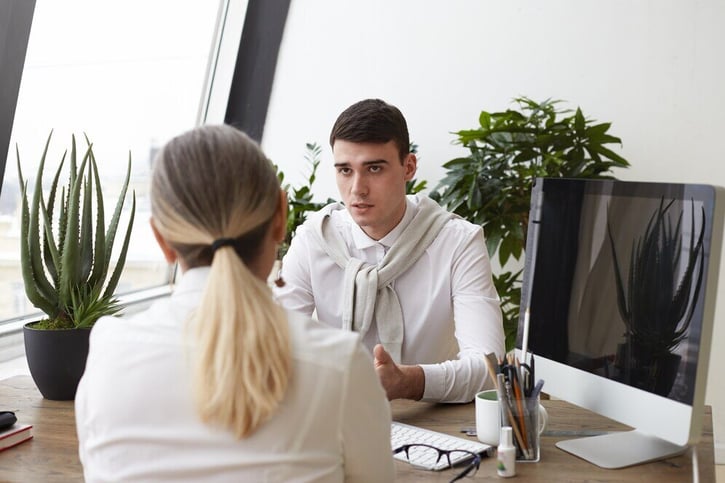 Arbeitnehmer bespricht Geburtsurlaub, auch sog. Vaterschaftsurlaub mit seinem Arbeitgeber.