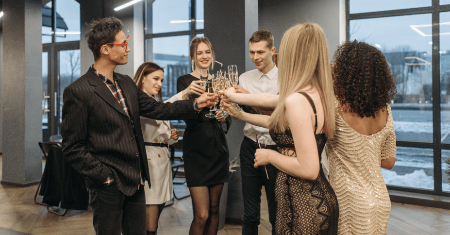 Collega's staan in een cirkel en klinken champagne glazen