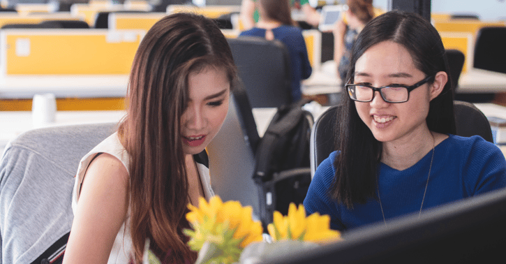 Collega's zitten aan een bureau en werken samen