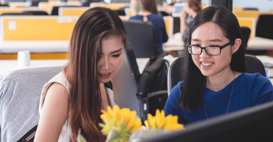 Collega's zitten aan een bureau en werken samen