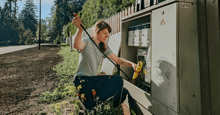 Vrouw werkt aan elektriciteitskast.