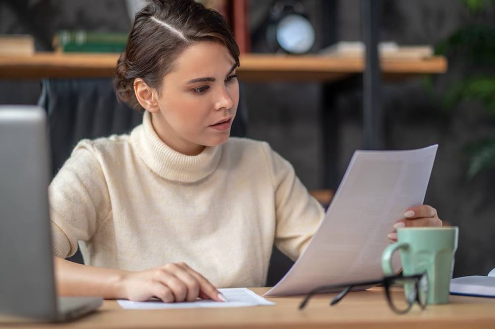 Arbeitsvertrag im Fokus: Arbeitnehmerin liest den Vertrag durch.