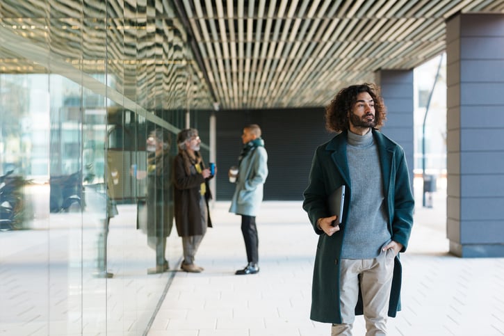 male employee leaving the office with laptop in hand