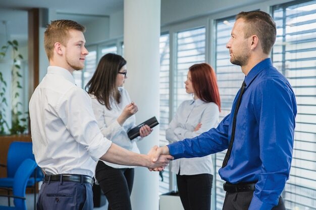 Kollegen verabschieden sich von einem Mitarbeiter am letzten Arbeitstag.