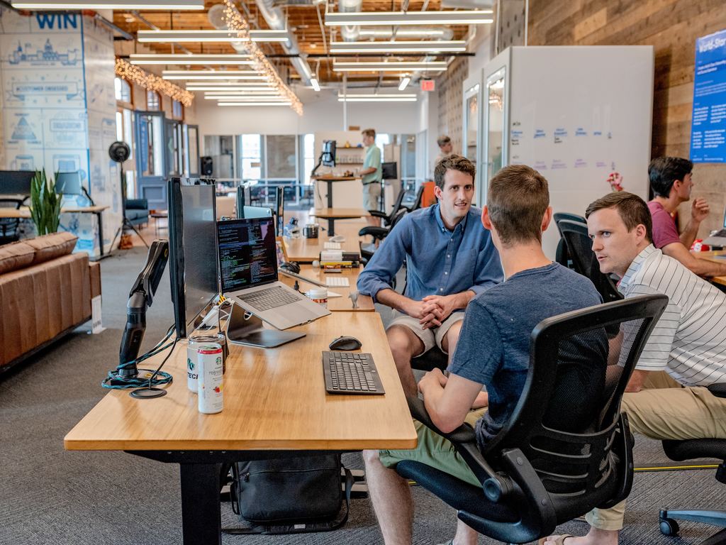 male coworkers discussing a project in an office meeting room