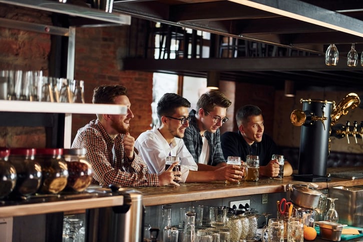 male group of friends sitting at a bar