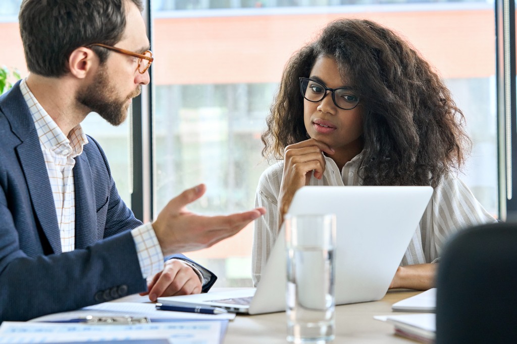 male mentor leader talking to female trainee at meeting table