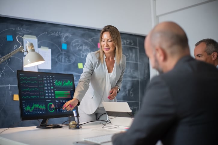 HR manager reviewing labour forecasting charts with team members in a meeting room
