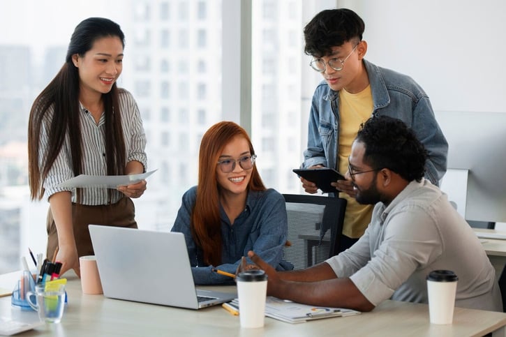 Workplace Diversity: Gruppenbild von Angestellten verschiedener Herkunft im Meetingraum.