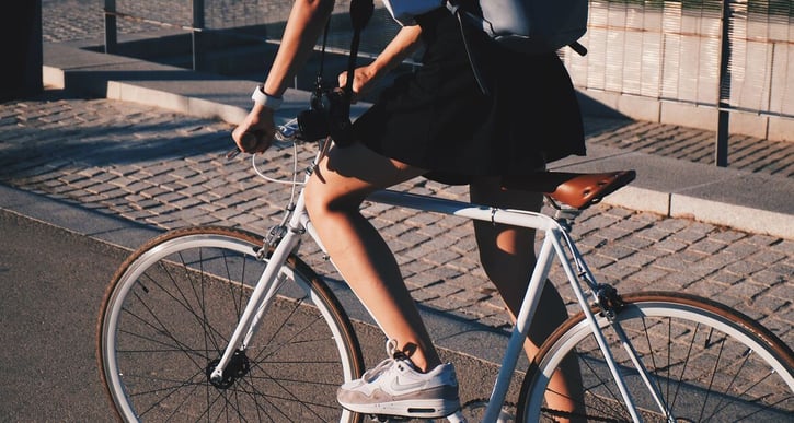 Vrouw zit op een racefiets. Alleen de onderkant van haar lichaam is in beeld.