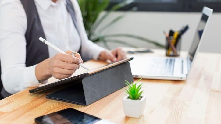Bild eines Arbeitgebers, der einen digitalen Arbeitsvertrag auf dem Tablet unterschreibt.