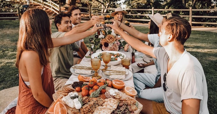 Vrienden zitten samen aan een gedekte tafel en proosten