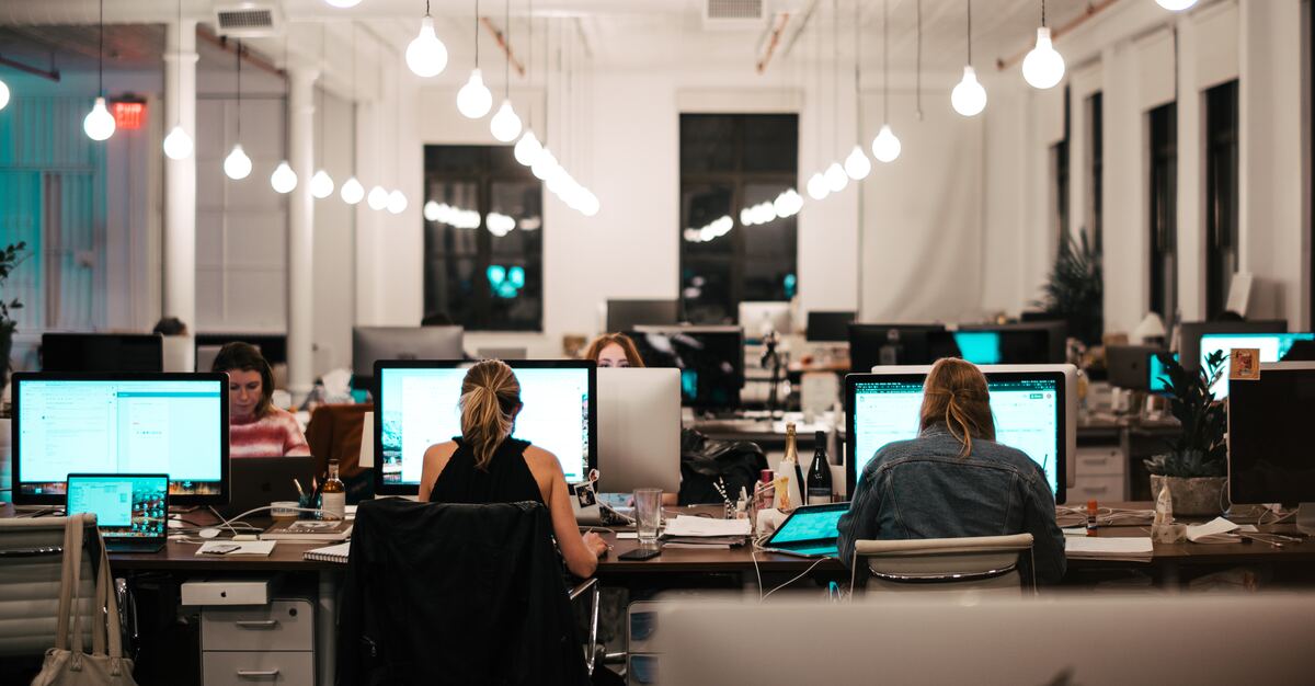 office with focused coworkers sitting at their desk and working on their computer